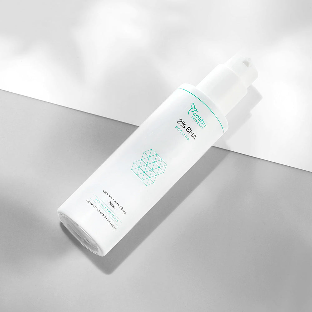 Weiße Flasche mit 2% BHA Peeling auf einem grauen und weißen Hintergrund, minimalistische Verpackung.
