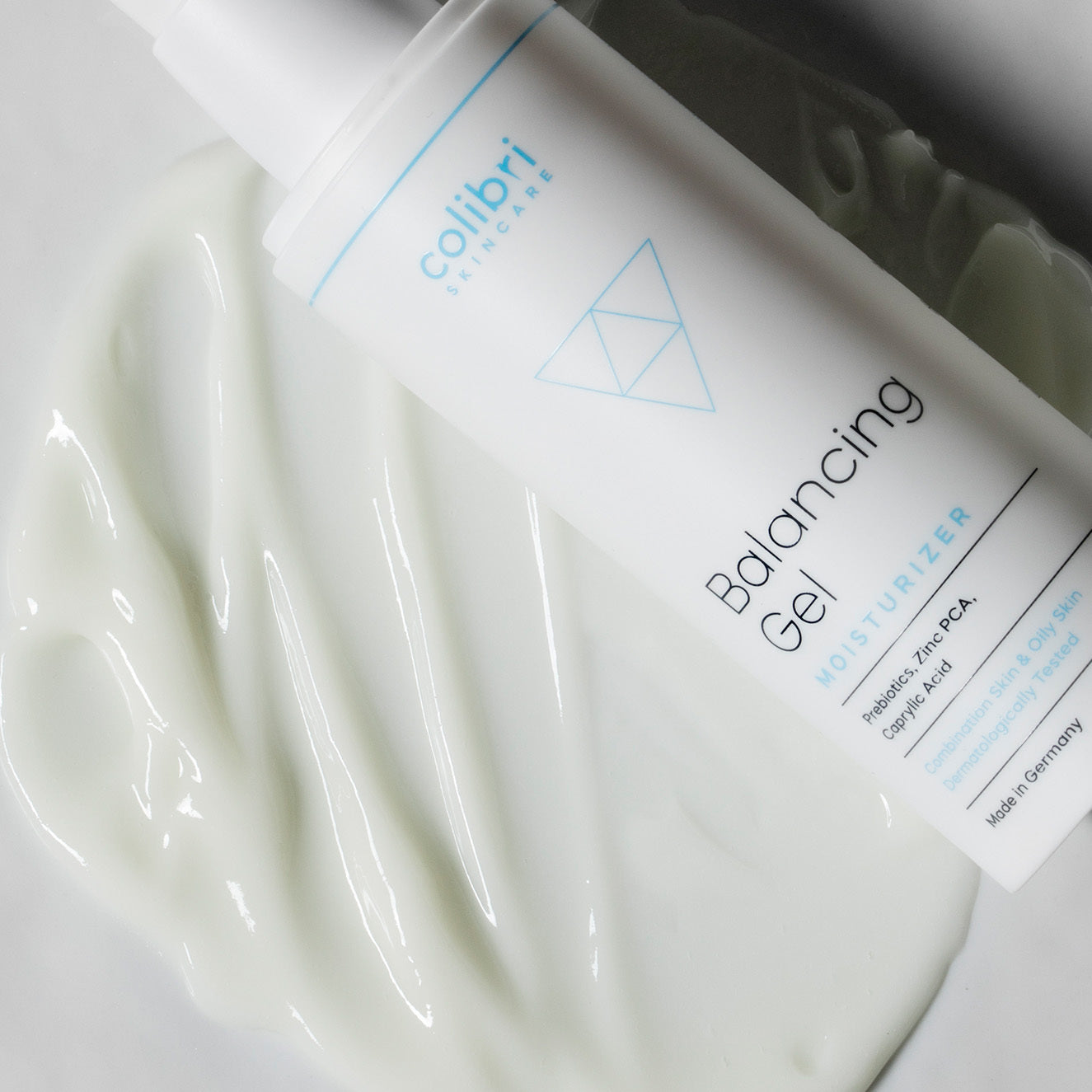 Weiße Flasche mit der Aufschrift "Balancing Gel Moisturizer" liegt auf einer cremigen, flüssigen Substanz.