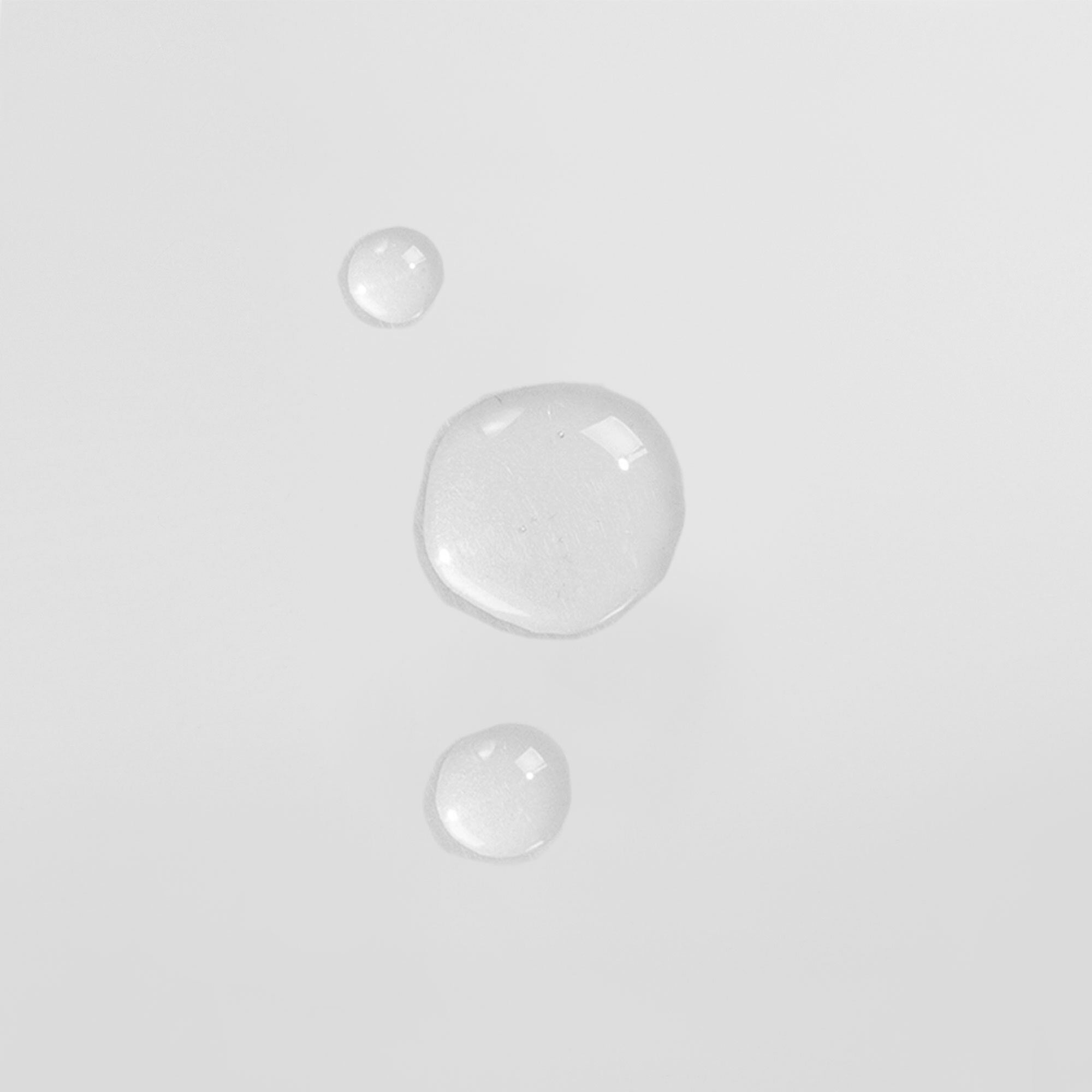 Drei transparente Wassertropfen auf weißem Hintergrund.