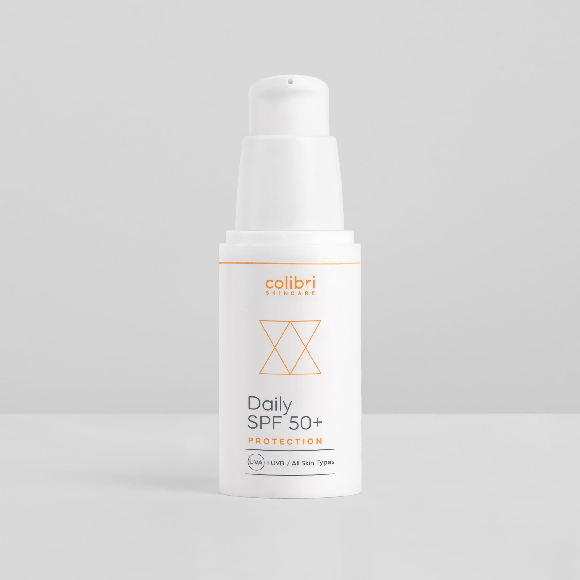 Weiße Flasche einer Sonnencreme mit der Aufschrift "Daily SPF 50+ Protection" auf grauem Hintergrund.