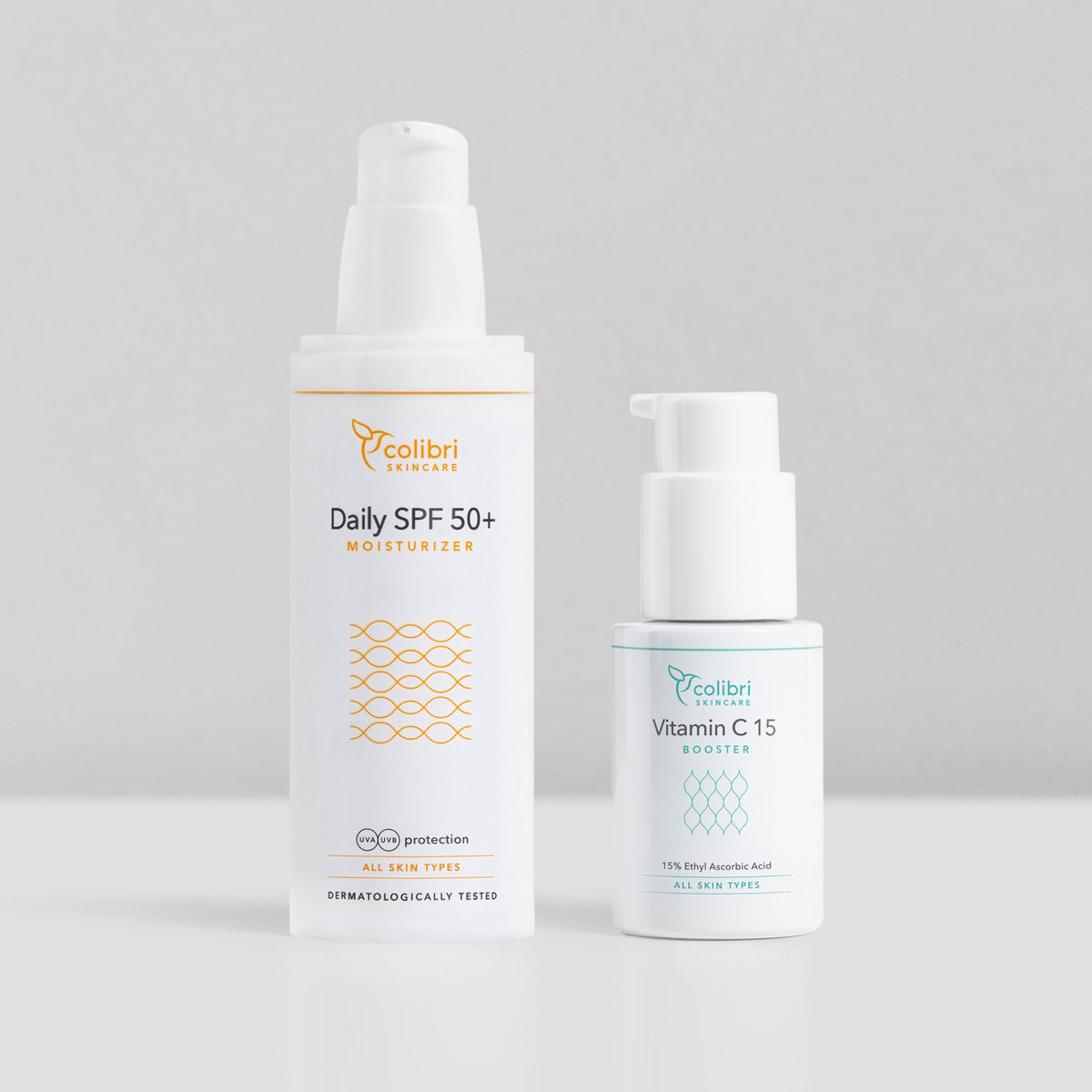 Zwei Hautpflegeprodukte von Colibri Skincare: ein Daily SPF 50+ Moisturizer und ein Vitamin C 15 Booster, stehen nebeneinander.