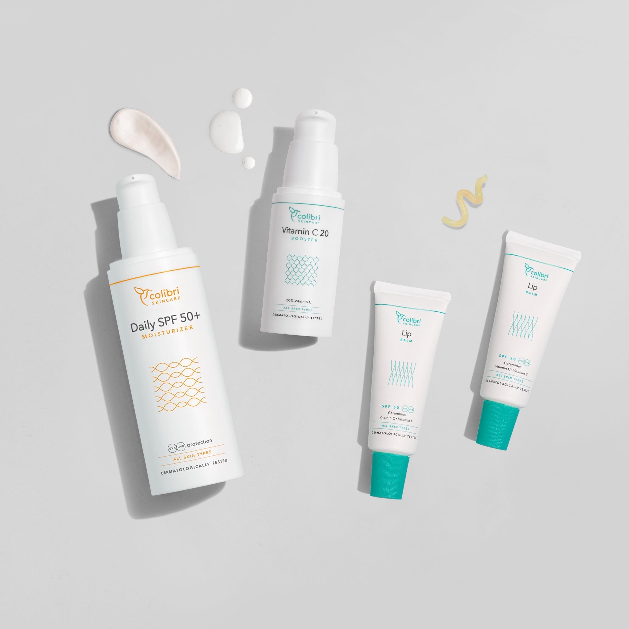 Vier Pflegeprodukte, darunter Sonnencreme, Vitamin C Booster und Lippenbalsam, auf grauem Hintergrund.