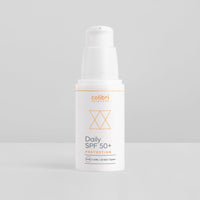 Weiße Flasche einer Sonnencreme mit der Aufschrift "Daily SPF 50+ Protection" auf grauem Hintergrund.